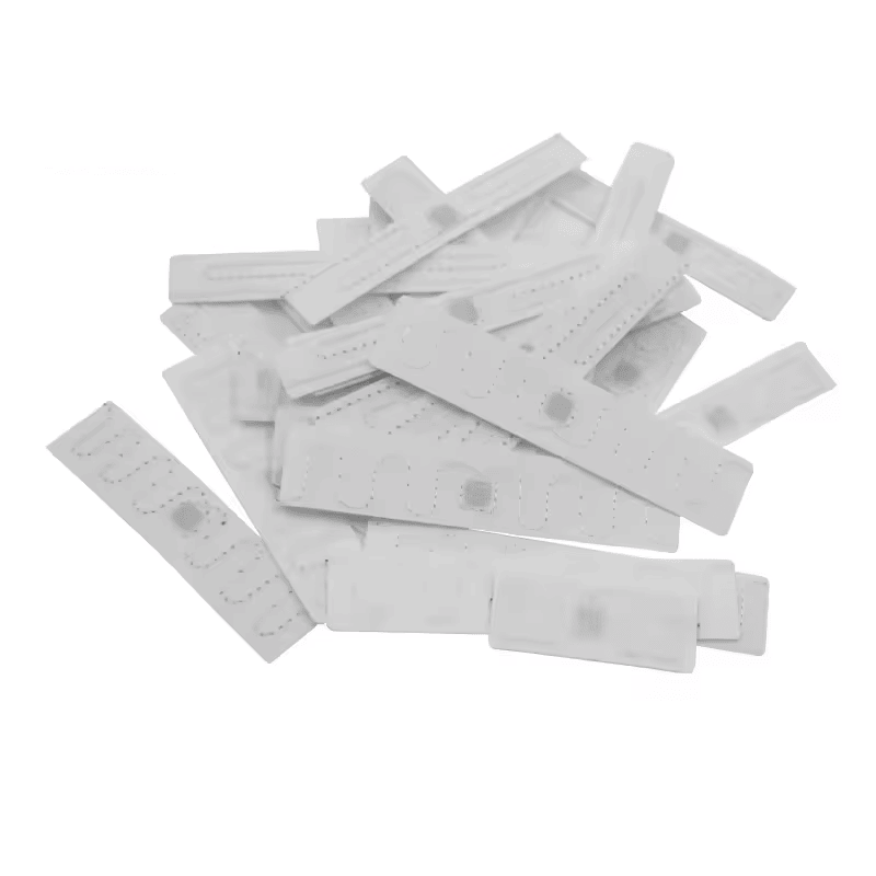 O grămadă de etichete de rufe RFID din poliester alb T7015-2 este afișată pentru a arăta calitatea consecventă a cusăturii și disponibilitatea pentru aprovizionare în vrac.