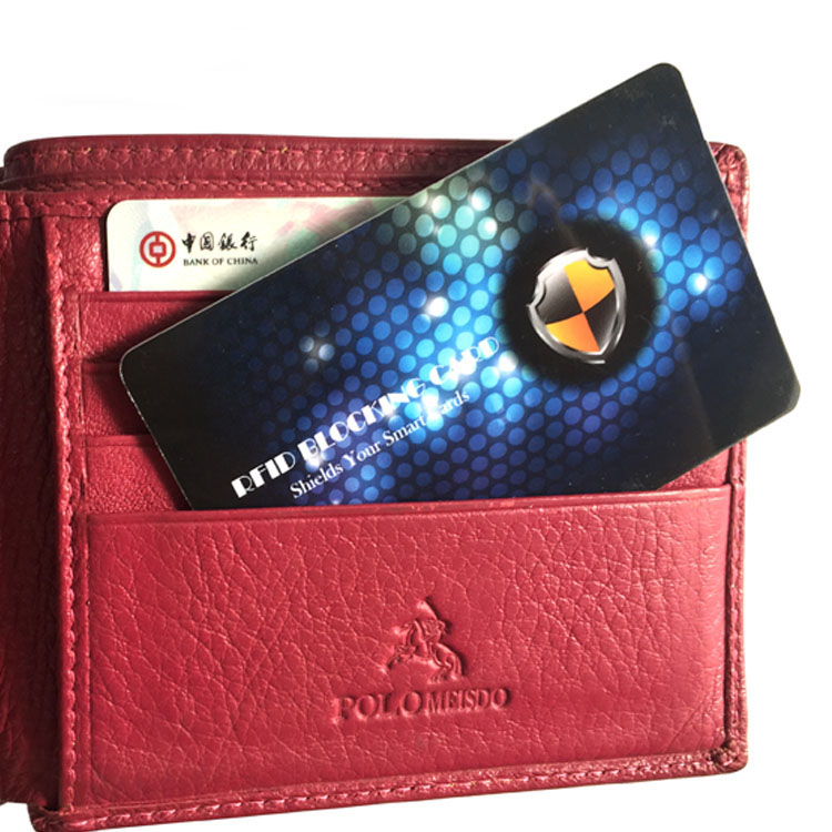 RFID card de blocare parțial introdus într-un portofel din piele roșie deasupra cardurilor bancare, care arată modul în care protejează cardurile în timpul transportului zilnic.