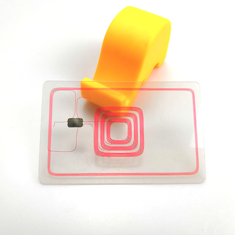 Cartelă de blocare RFID transparentă care arată bobină de antenă imprimată și cip încorporat cu un suport portocaliu în spate pentru vedere tehnică de aproape.