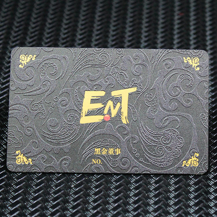 Carte de vizită metalică premium închisă la culoare, cu textură ornamentală și logo ENT auriu, într-un stil de card VIP high-end.