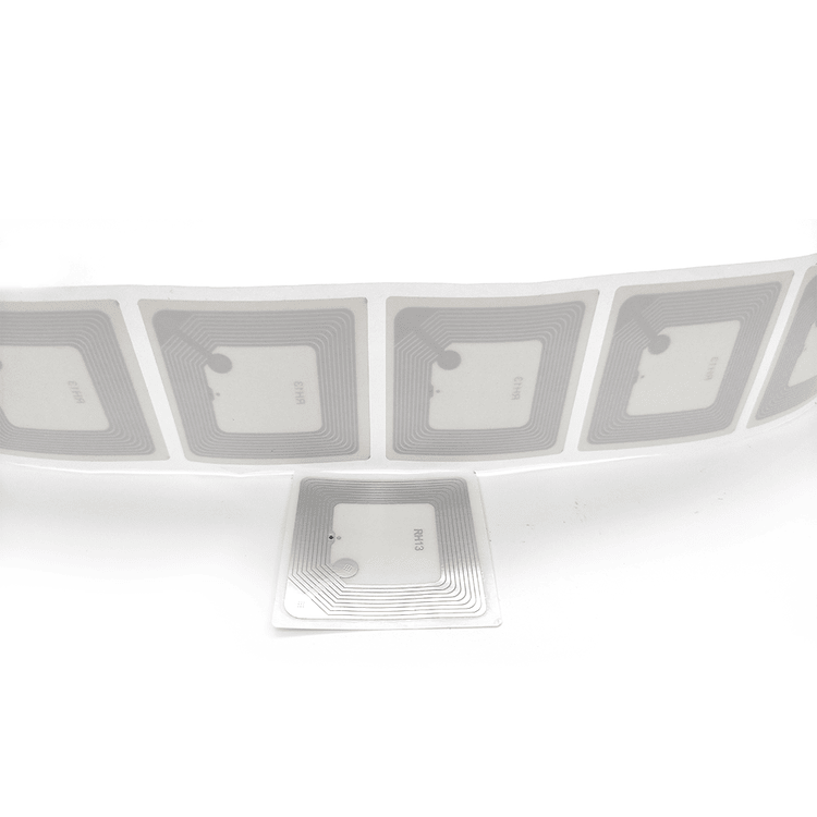 Această imagine de aproape prezintă o bandă de etichete RFID pentru cărți și o etichetă separată, pentru a ilustra designul inlay-ului.
