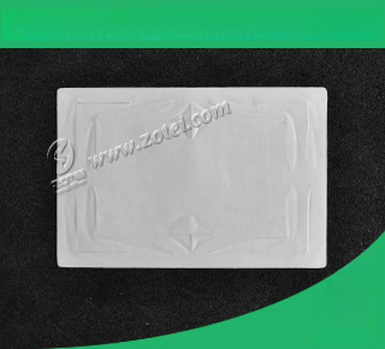 O singură etichetă goală UHF de parbriz RFID se află plat pe un fundal negru; cu colțuri verzi care evidențiază fața netedă și imprimarea antenei.