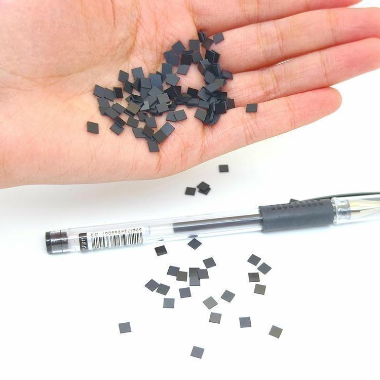 SV-001 micro RFID POD etichete într-o mână cu un stilou în apropiere arată scara și adecvarea pentru etichete de materiale încorporate la temperaturi ridicate.