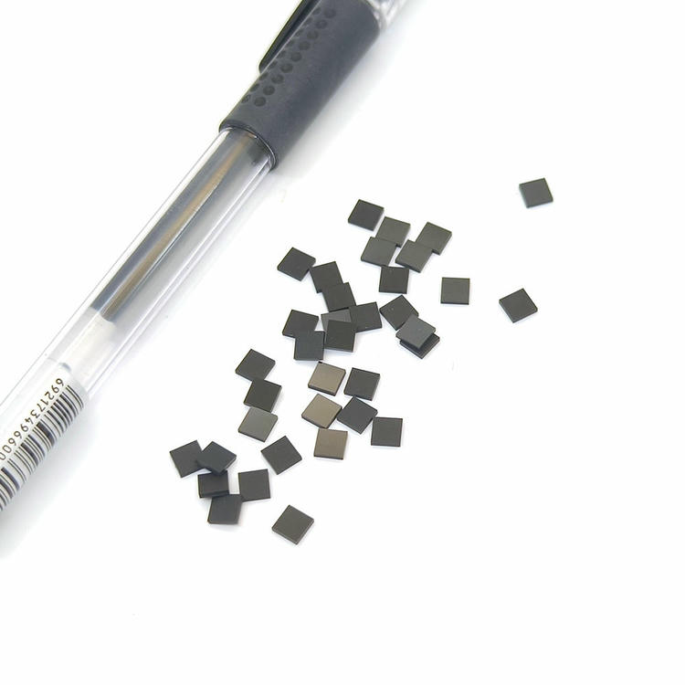 Etichetele SV-001 micro RFID POD împrăștiate lângă un stilou arată forma pătrată 4x4mm utilizată pentru identificarea la temperaturi înalte încorporate.
