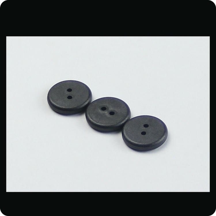 Fotografia arată trei etichete RFID PPS sew-on PPSD21-1 aliniate diagonal, evidențiind corpul subțire tip buton cu două orificii de coasere.