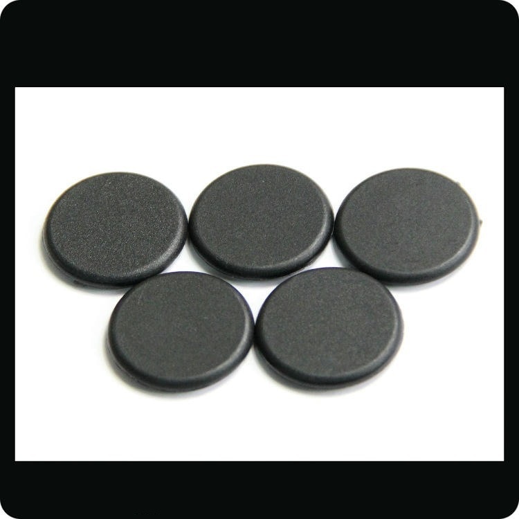 Cinci discuri negre de tag RFID PPS model PPSD30-1 aranjate pe fundal alb, evidențiind designul robust pentru spălătorii industriale.