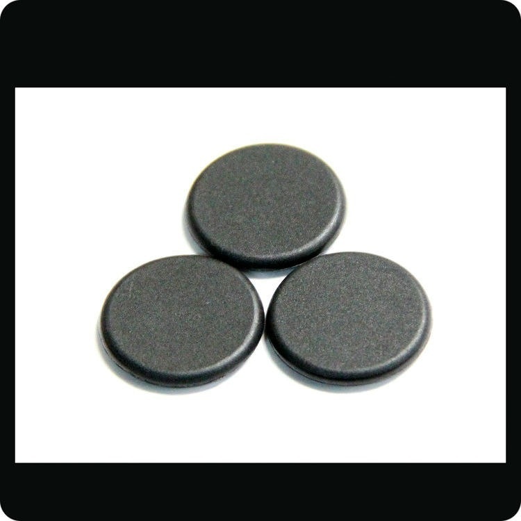 Trei discuri negre de tag RFID PPS model PPSD30-1 pe fundal alb, evidențiind forma rigidă tip monedă pentru rufe și active.