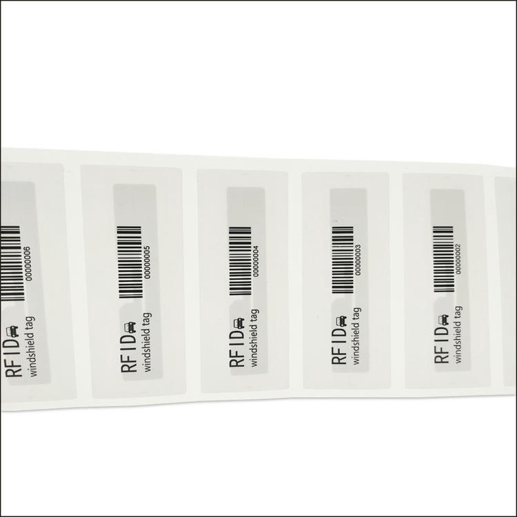 Vedere apropiată a UHF parbriz RFID bandă de etichete cu cod de bare și marcaj de serie pentru autentificarea sigură a controlului accesului la vehicule.