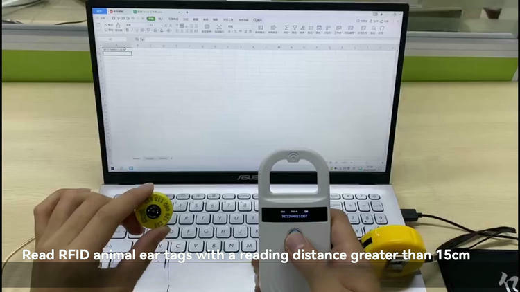 Fotografia de test real arată FS-200 citind o crotalie lângă ecranul unui laptop, demonstrând distanța de citire mai mare în utilizare.