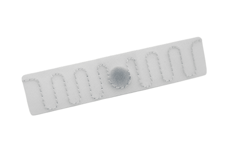 Prim-plan al unei etichete albe Polyester RFID Laundry Tag T7015-2, cu margine cusută și zonă centrală pentru cip, pentru identificare UHF fiabilă.