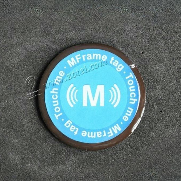 Mostră de tag RFID anti-metal din epoxid D40mm, afișată ca un tag circular albastru pe fundal închis, cu grafică contactless imprimată.