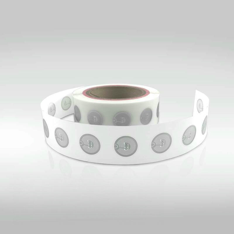 Un utilizator atinge cu smartphone-ul o etichetă NFC rotundă pentru a declanșa rapid o experiență digitală sau pentru a deschide un link dedicat.