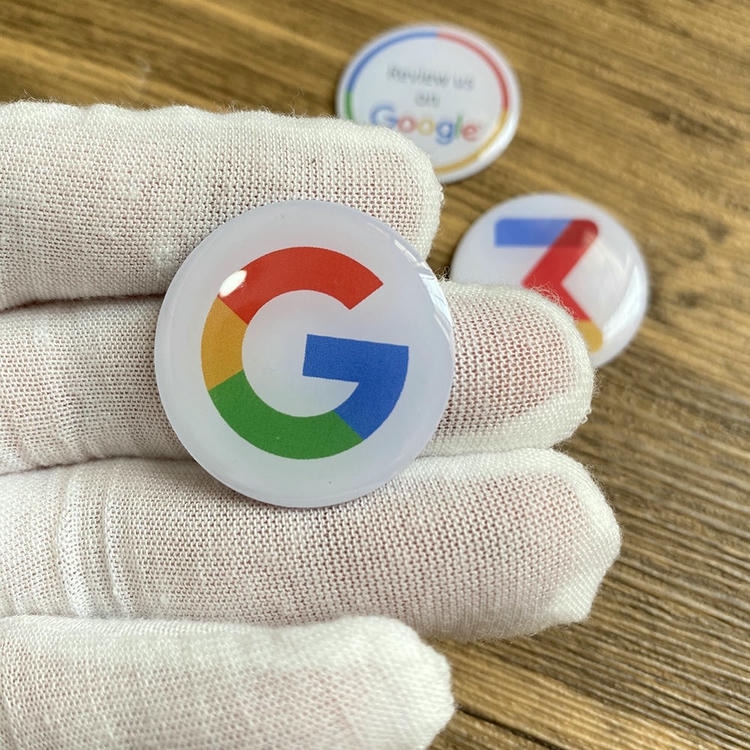 Autocolant epoxidic NFC de formă personalizată; ținut cu o mână înmănușată; care arată o insignă rotundă în stil logo cu protecție epoxidică lucioasă pentru promoții.